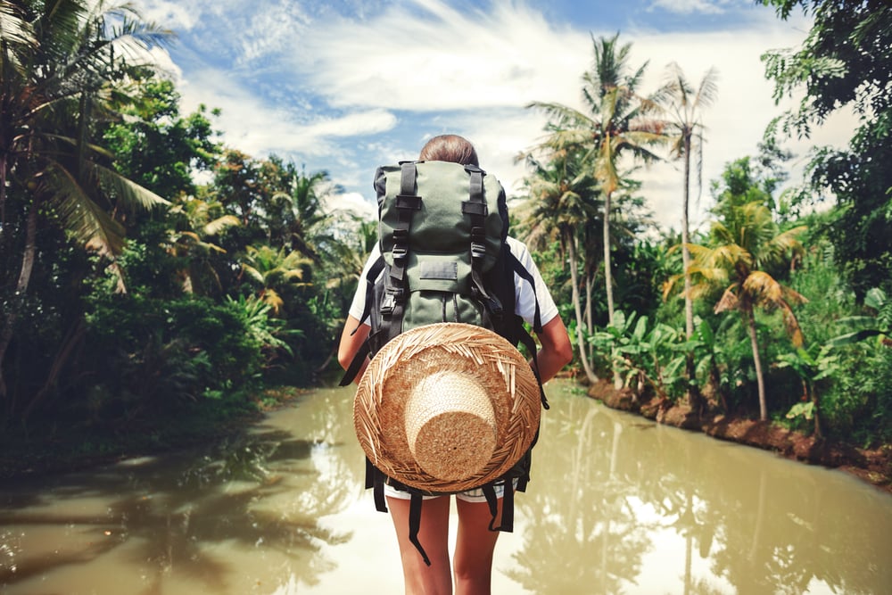 femme qui voyage avec sac à dos dans la forete