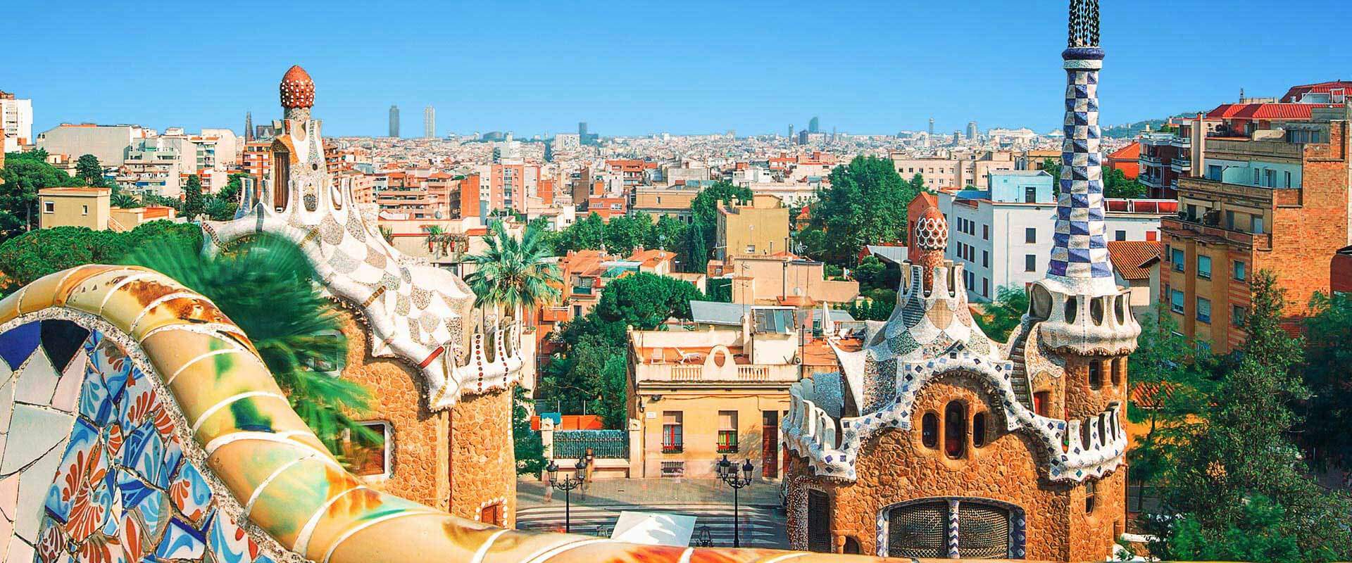 Vue panoramique du parc Güell à Barcelone, avec ses structures colorées de Gaudí et la ville en arrière-plan.