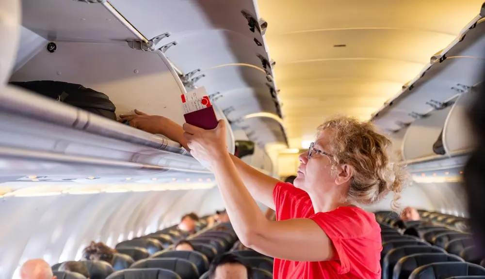 Passagers rangeant leurs bagages dans l'avion