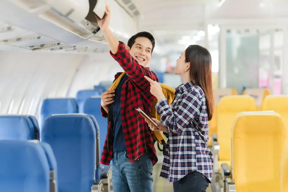 Passager aidant un autre à ranger sa valise